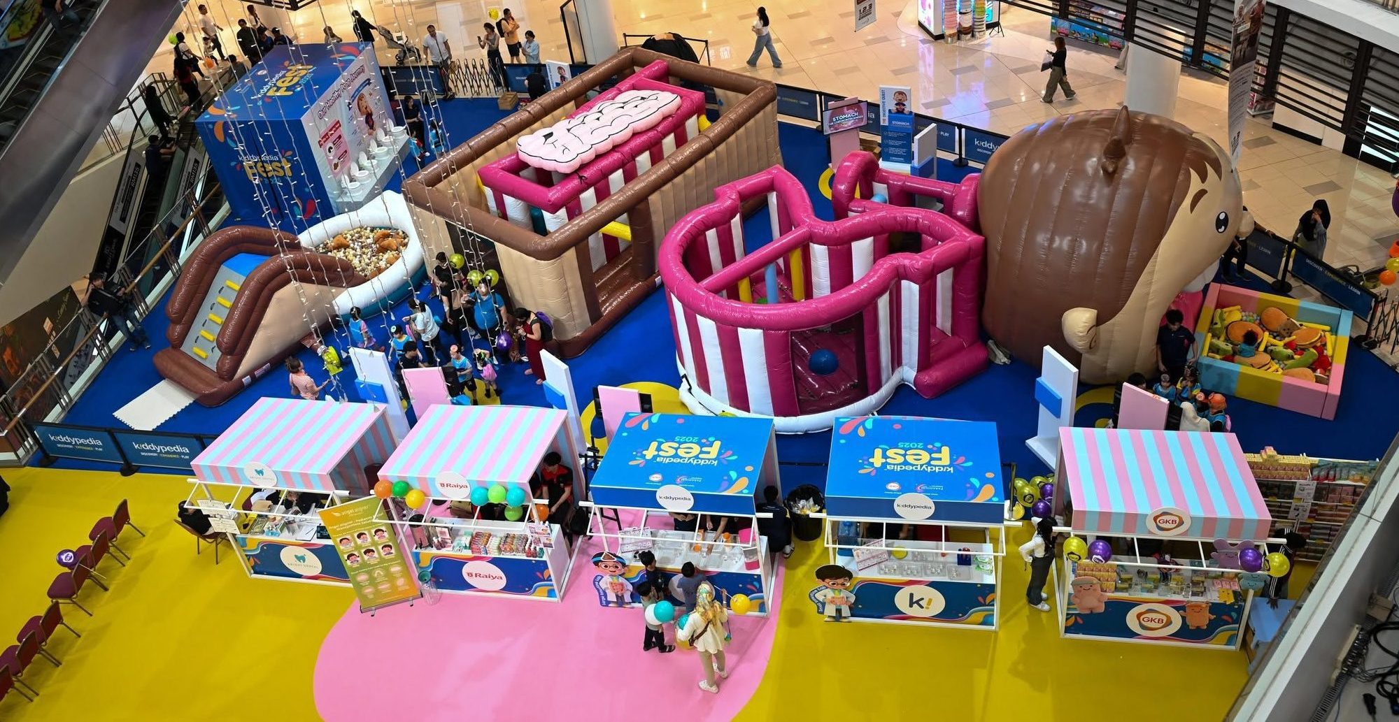 Aerial view of the life-sized inflatable Digestive Quest build inside a shopping mall, with families exploring the zones.